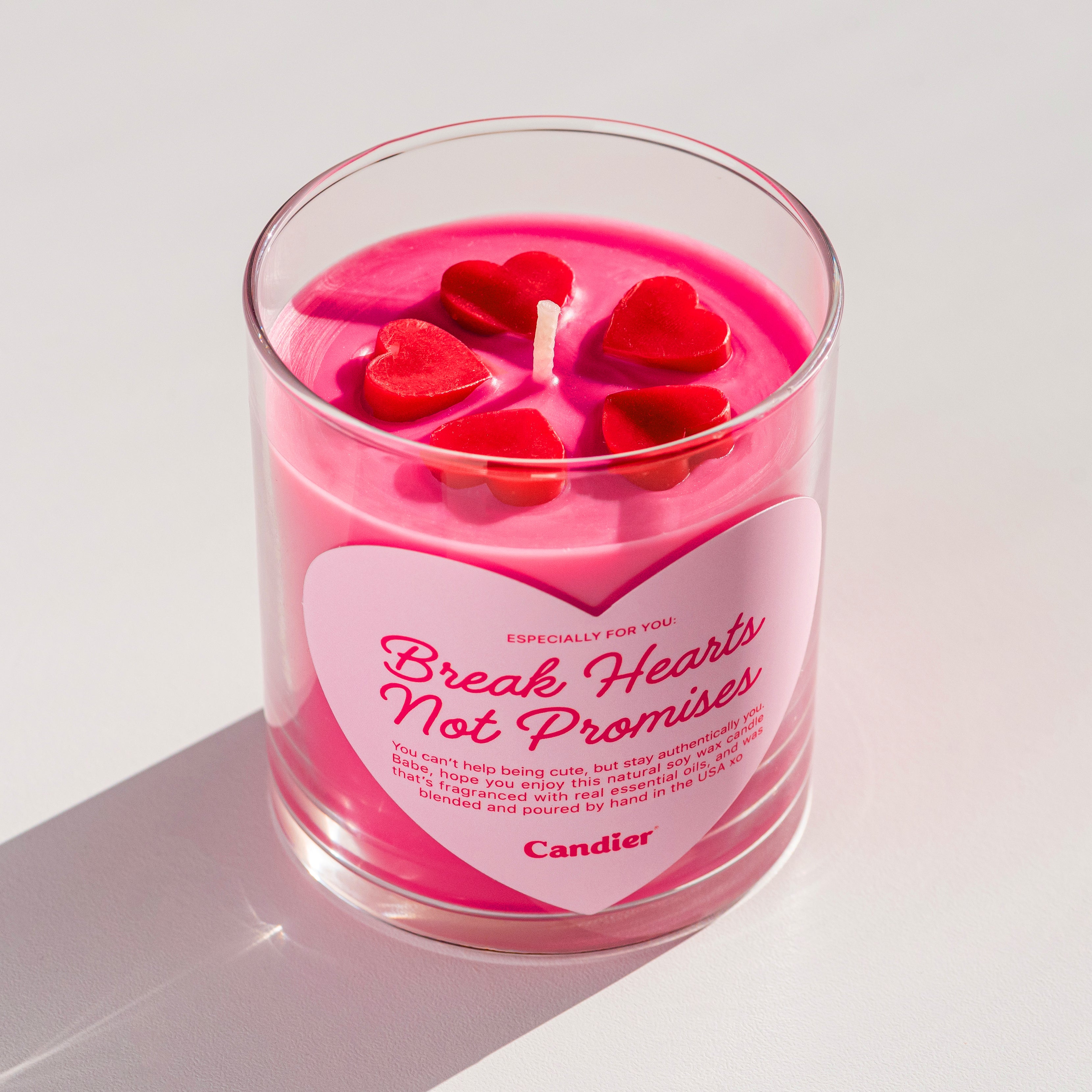 Cute pink candle with molded wax hearts and a big heart shaped label that reads Break Hearts Not Promises, by Candier® candles