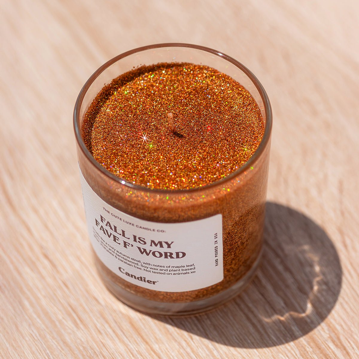 Candier candles Fall Is My Fave F Word, a cozy cashmere falling leaves candle with plant-based glitter and luxe autumn fragrance.