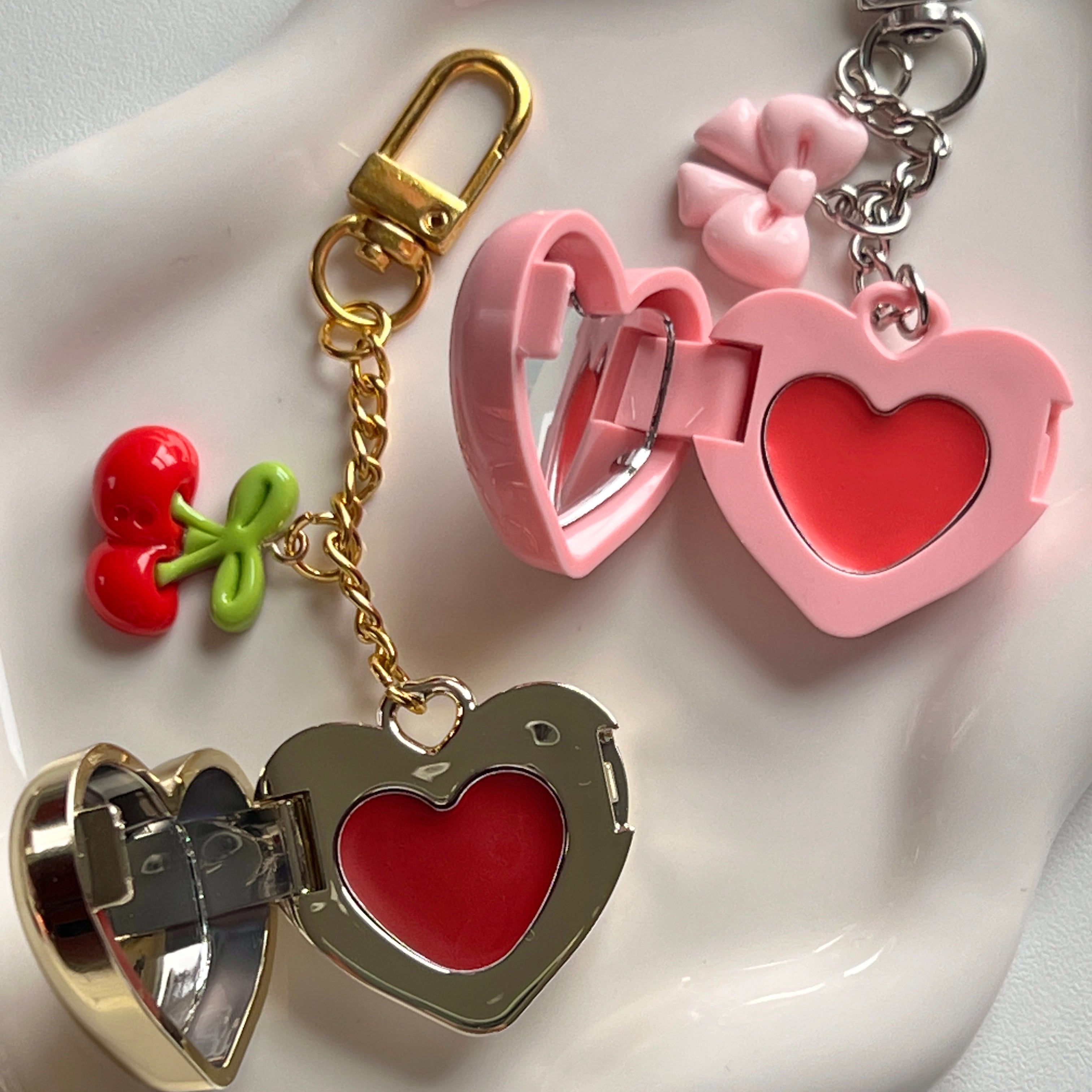 Gold and pink heart lip balm lockets with cherry and bow charms – cute gifts for friends