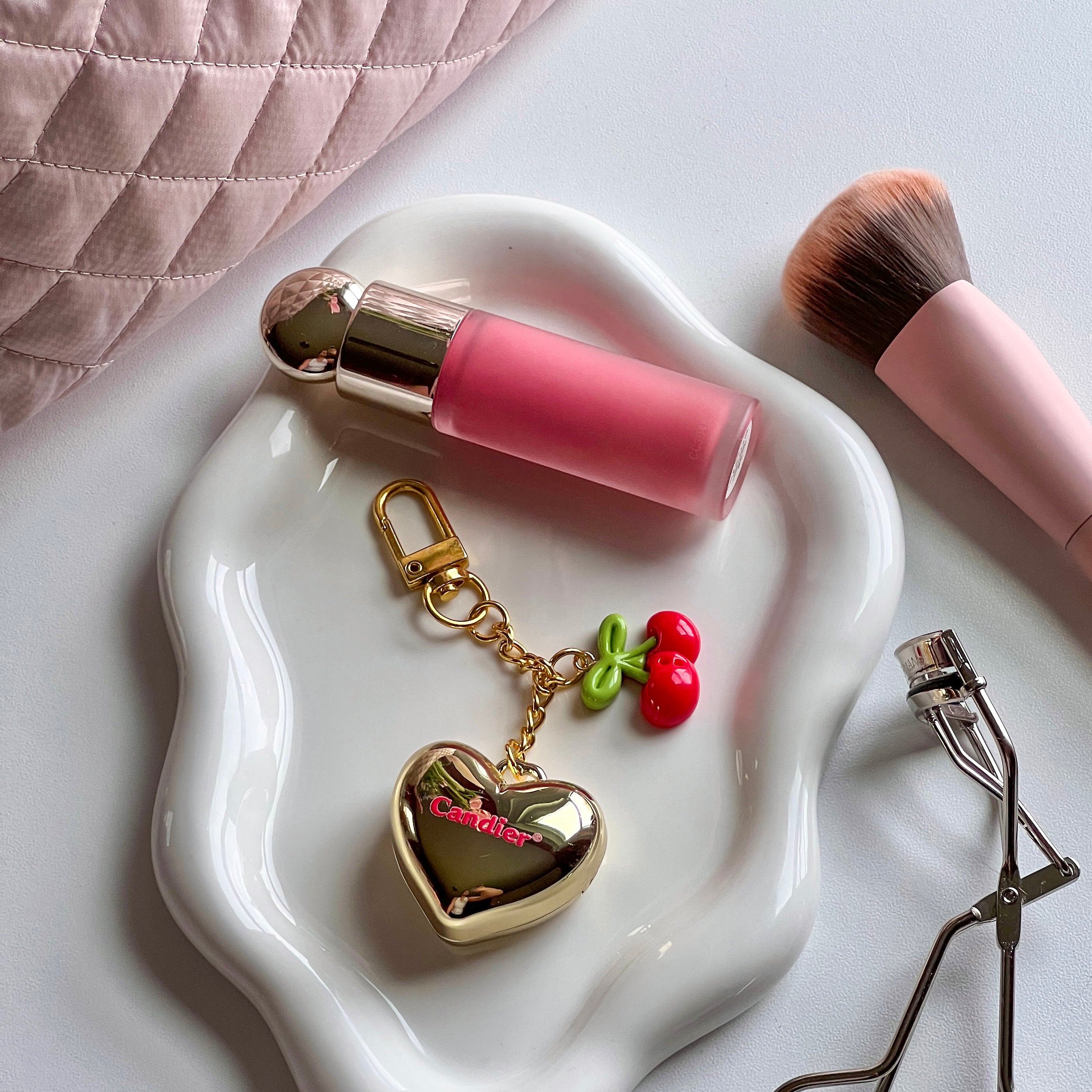 Gold heart keychain locket with red balm shown beside lipstick â 90s aesthetic and glossy lips