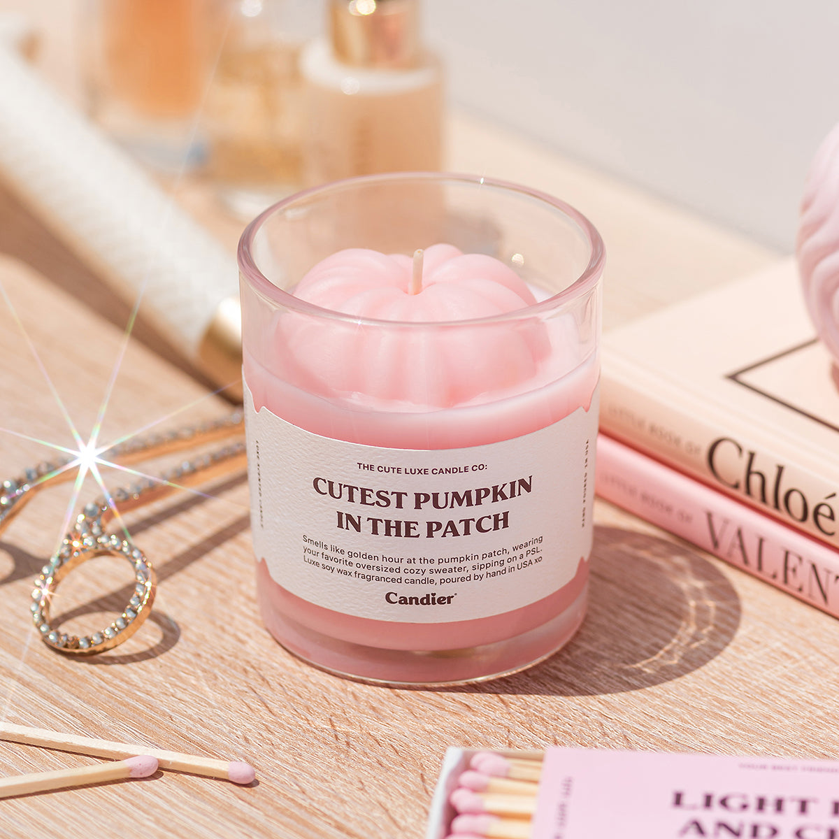 Cutest Pumpkin in the Patch candle styled with jewelry. Cute aesthetic pink pumpkin candle, best gifts for a young woman.