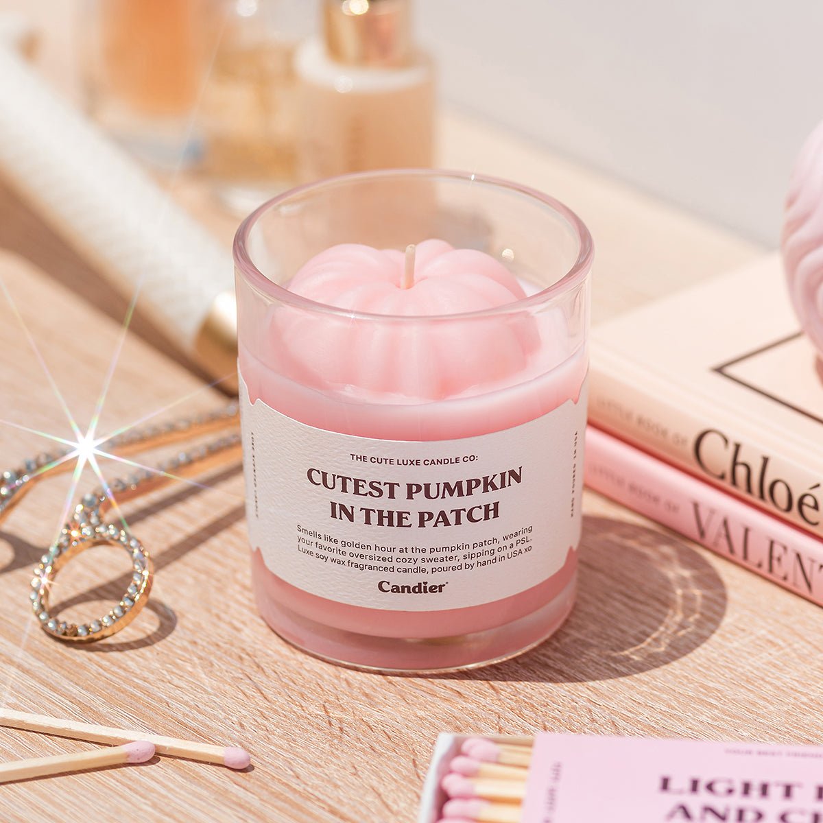 Cutest Pumpkin in the Patch candle styled with jewelry. Cute aesthetic pink pumpkin candle, best gifts for a young woman.