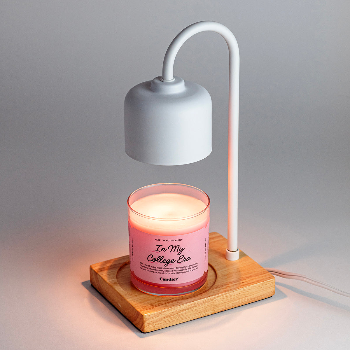 Aesthetic white wax melt lamp warming a pink Candier candle wax melt on a wood base. Cozy dorm-friendly flameless candle setup.