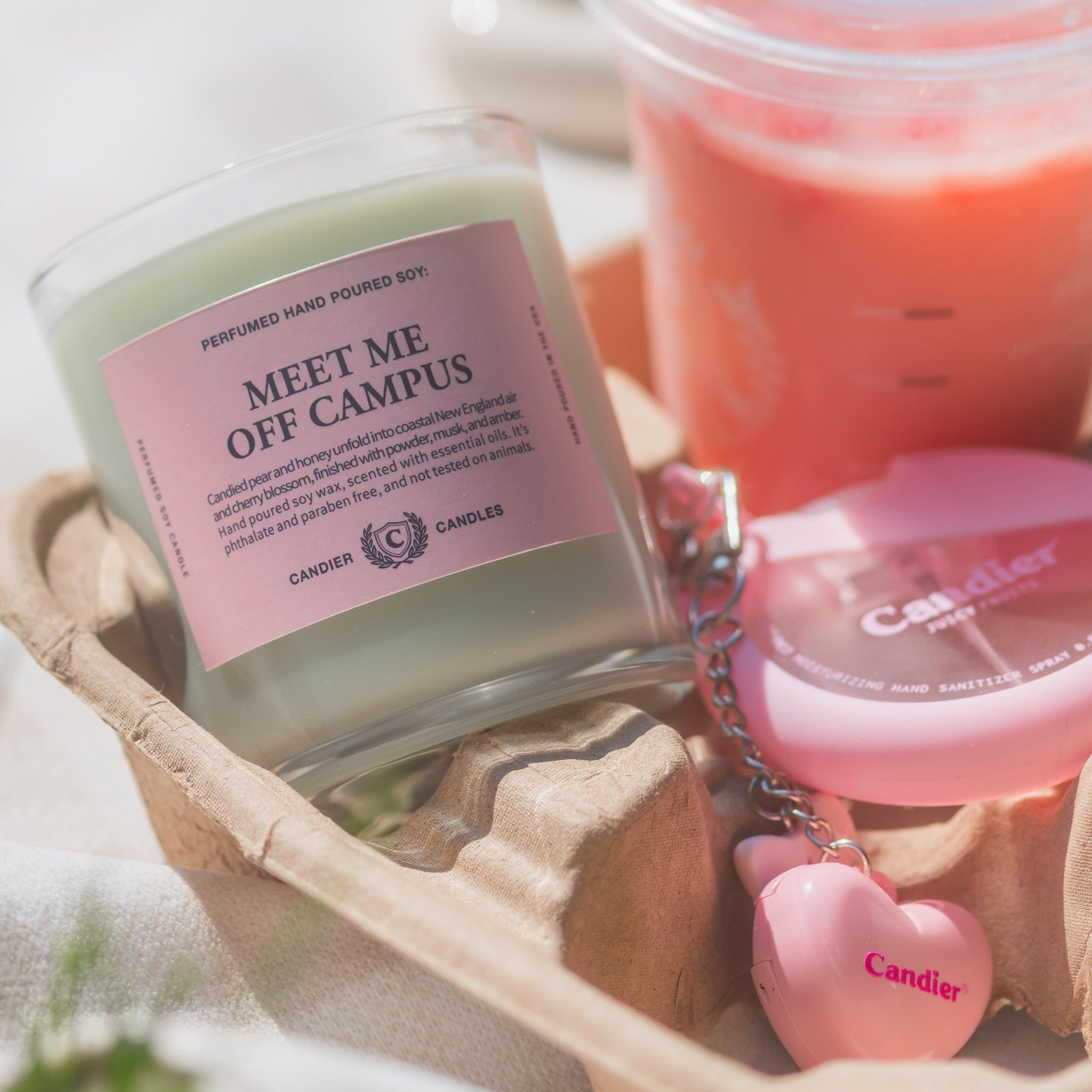 Meet Me Off Campus green candle styled with pink accessories for a cute college dorm aesthetic