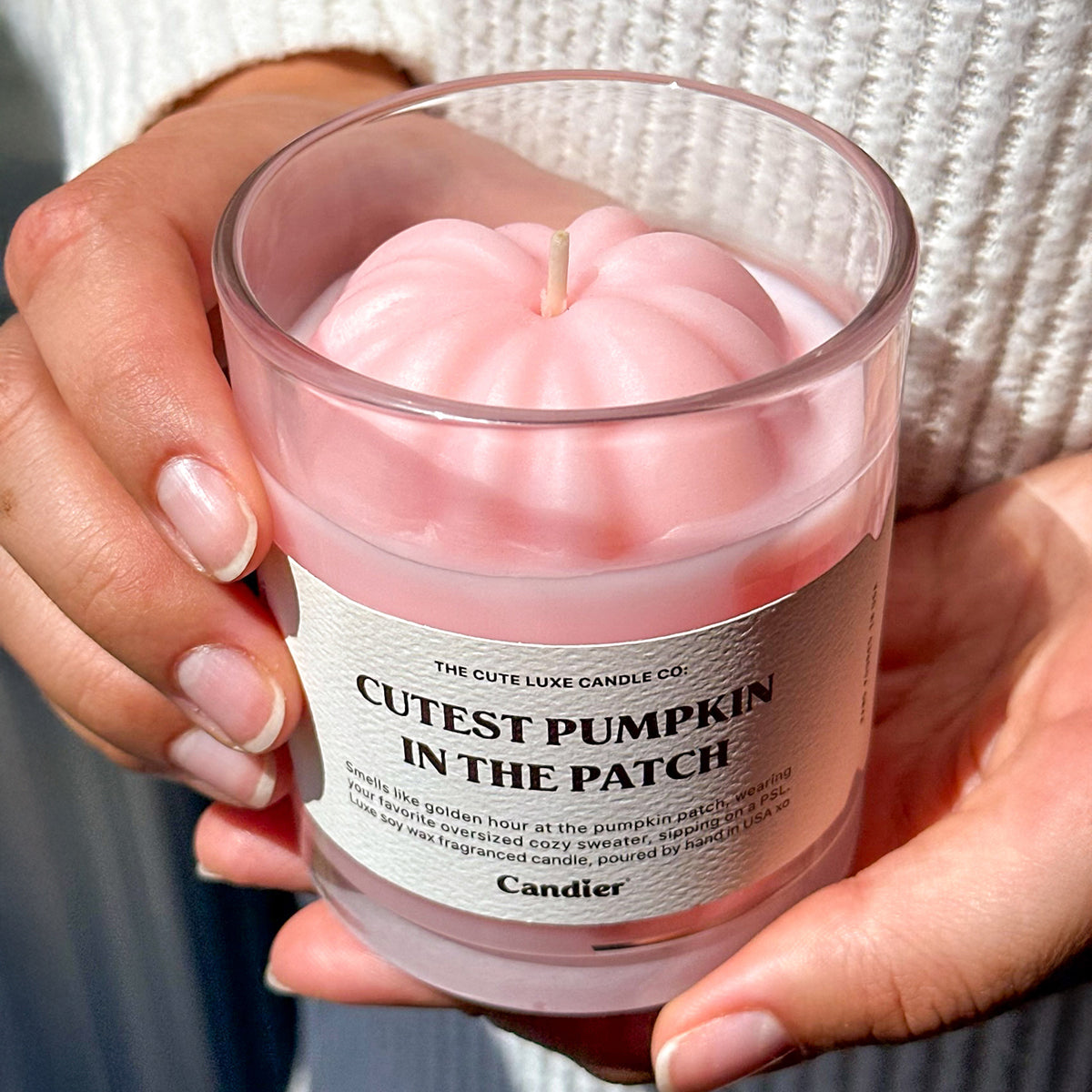 Close-up of pink pumpkin decor candle in glass jar. Cozy candles and luxe aesthetics for fall, perfect cute gifts for her.