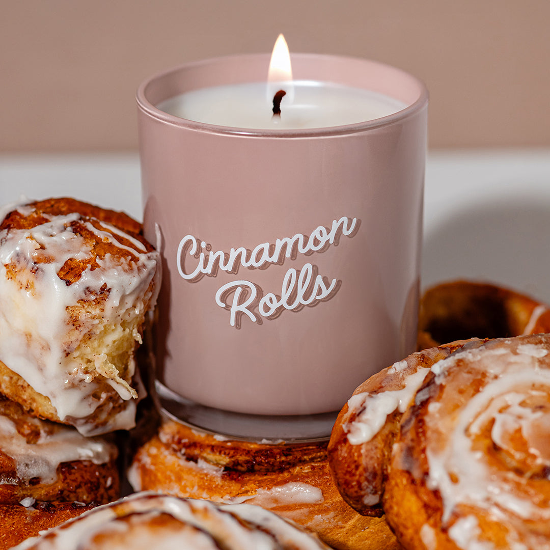 Candier Cinnamon candle styled with fresh cinnamon rolls and vanilla scent glaze. Aesthetic food dessert candle