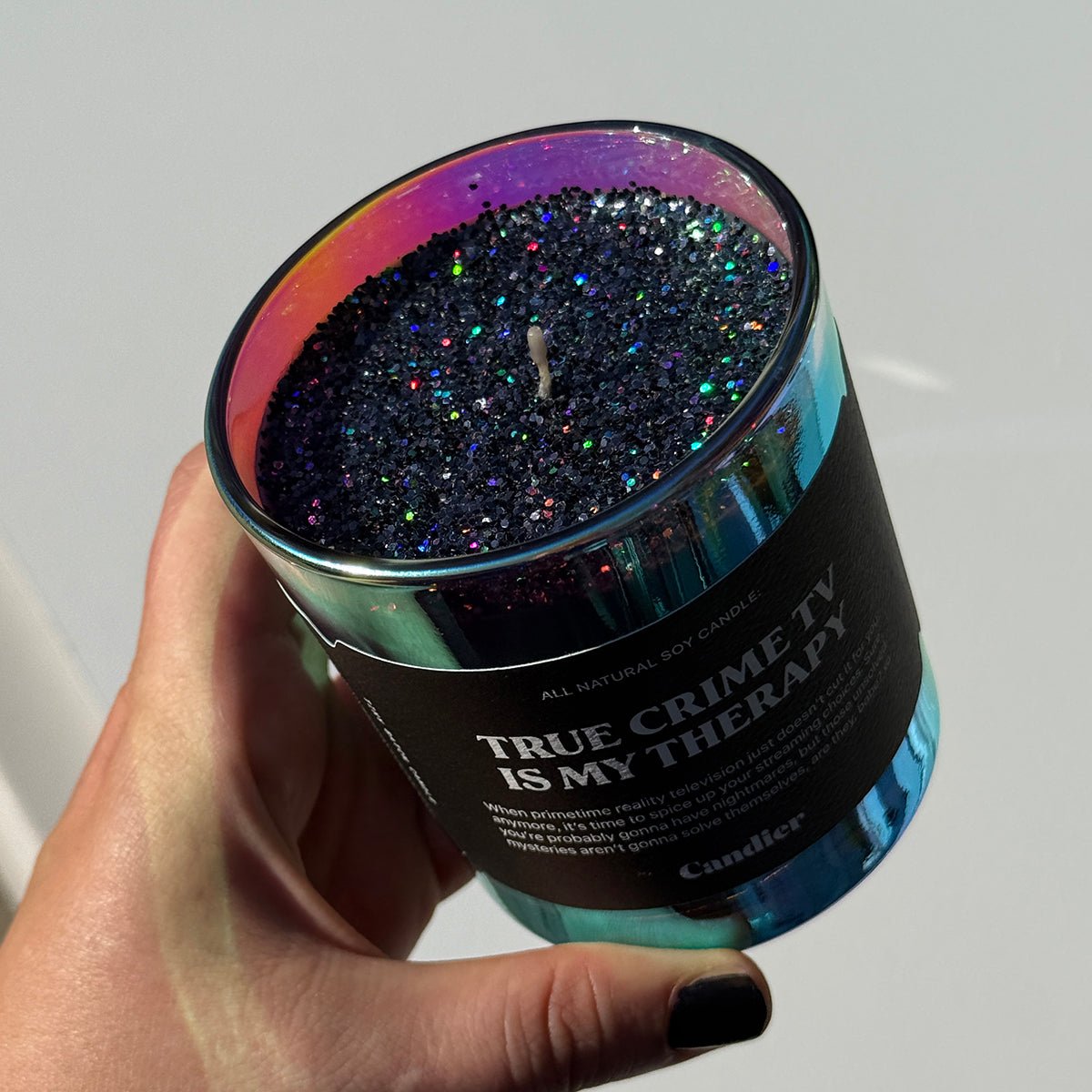 Candle with plant based glitter held by a hand, labeled 'True Crime TV is My Therapy' halloween candle great for boo baskets for girlfriends