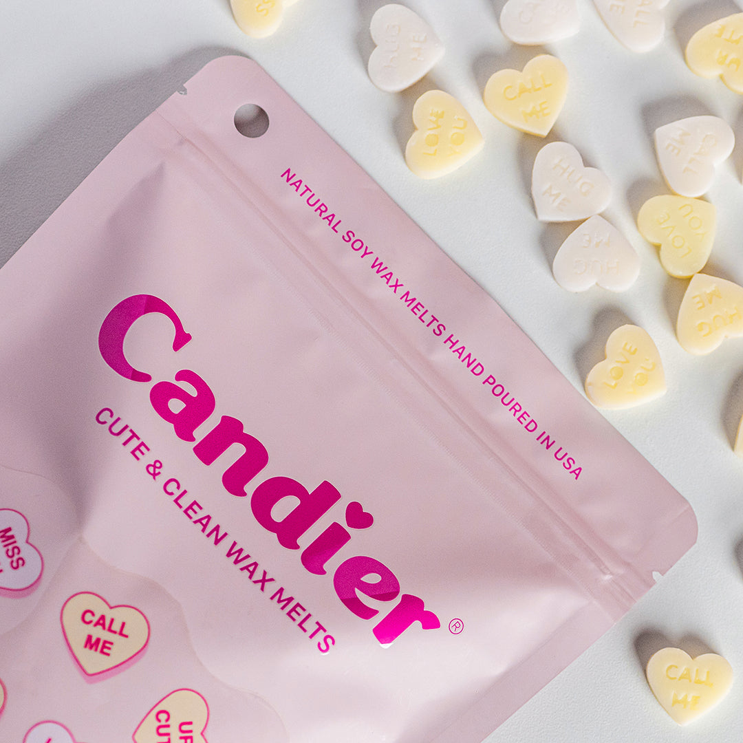 Flatlay showing Candier Vanilla Frosting Wax Melts pouch with heart-shaped melts scattered around it. Clean, cute gift for teen girls and Vanilla Girl fans.