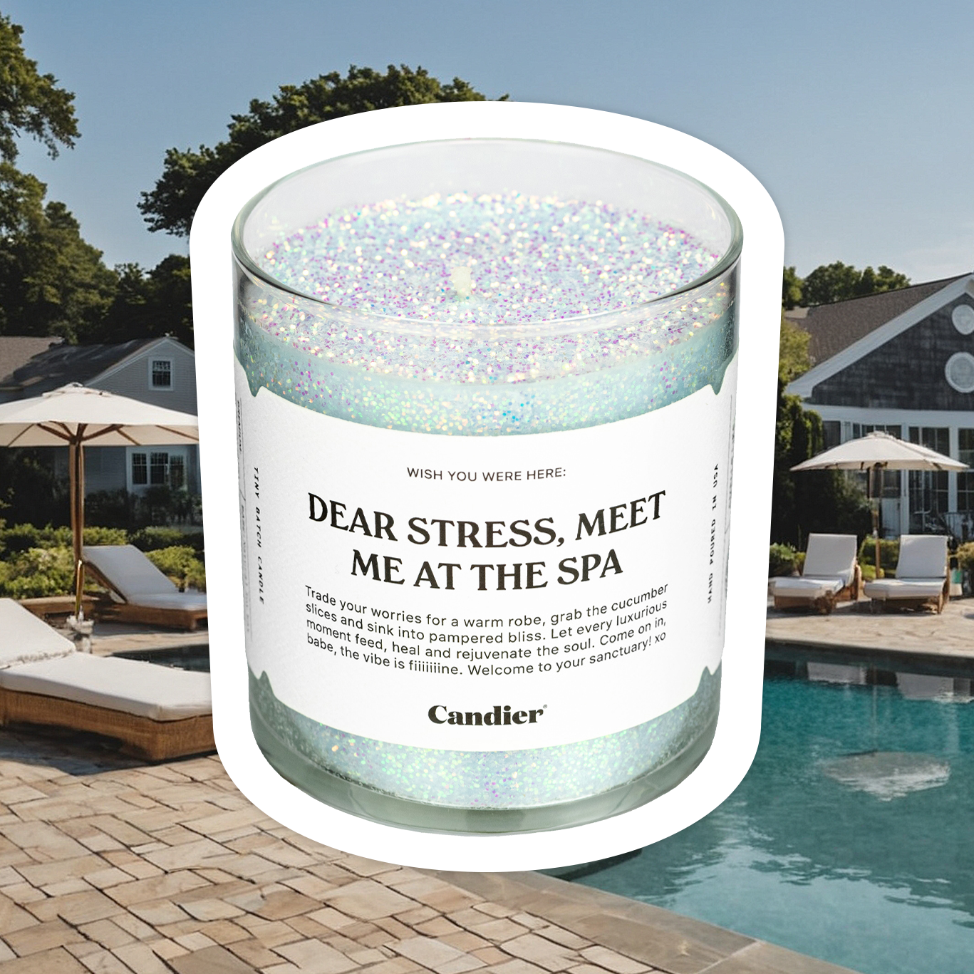 a sparkling ocean blue candle with plant based glitter and a label that reads Dear Stress Met Me At The Spa, on a background of a fancy spa with swimming pool