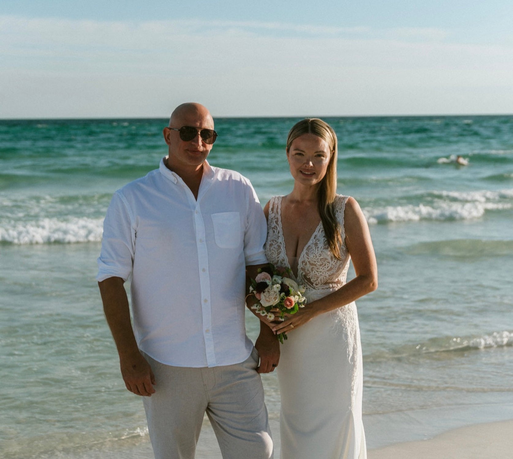 Man and woman standing on a beach with ocean in the background