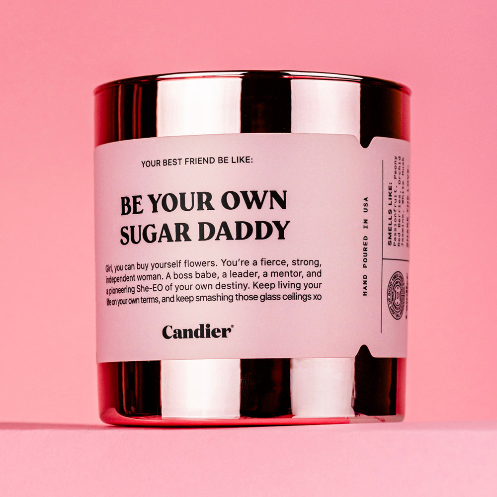 a pink and rose gold metallic candle with a label that reads Be Your Own Sugar Daddy