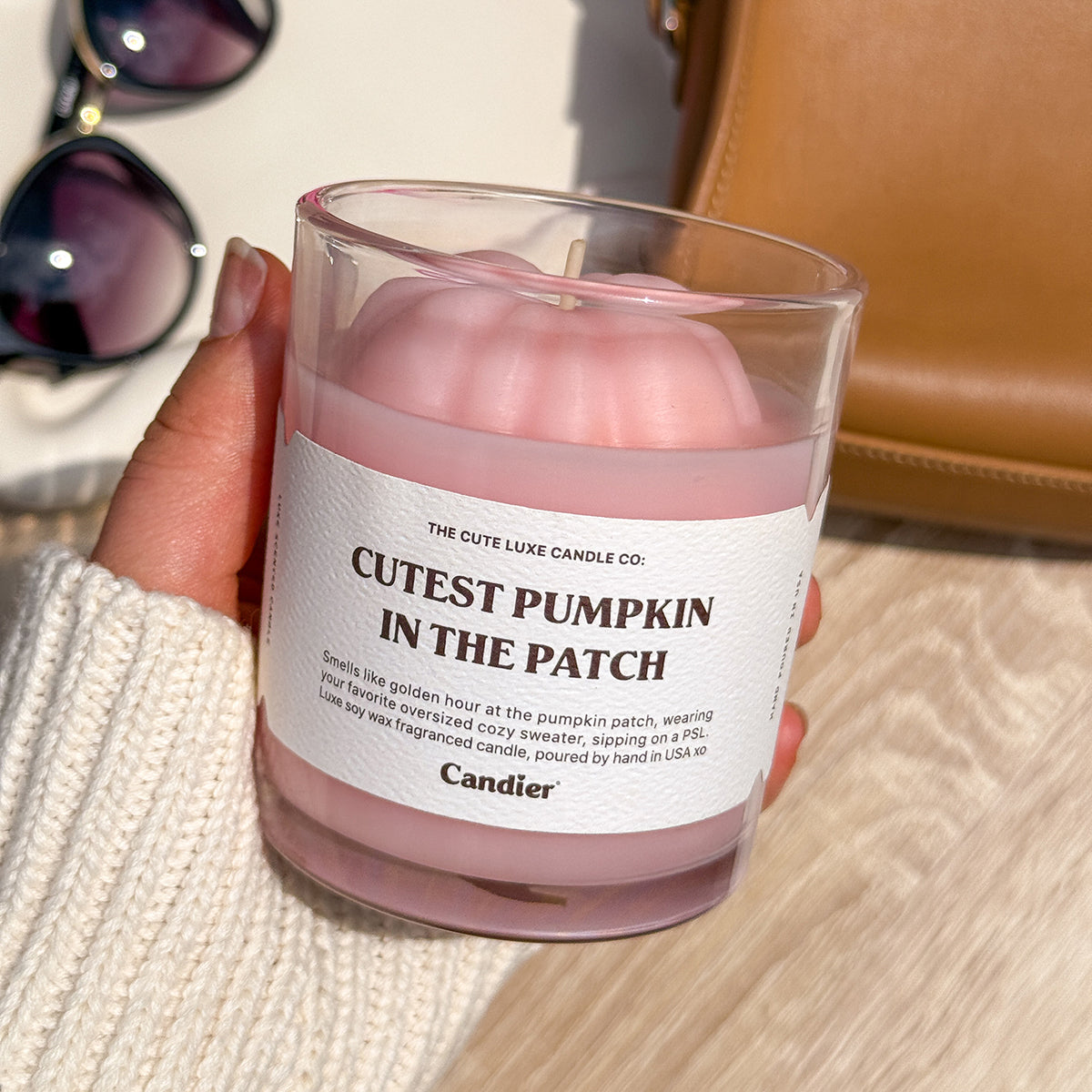 Hand holding Candier Cutest Pumpkin in the Patch candle. Cute candles and cozy sweater weather vibes, perfect fall scented candles