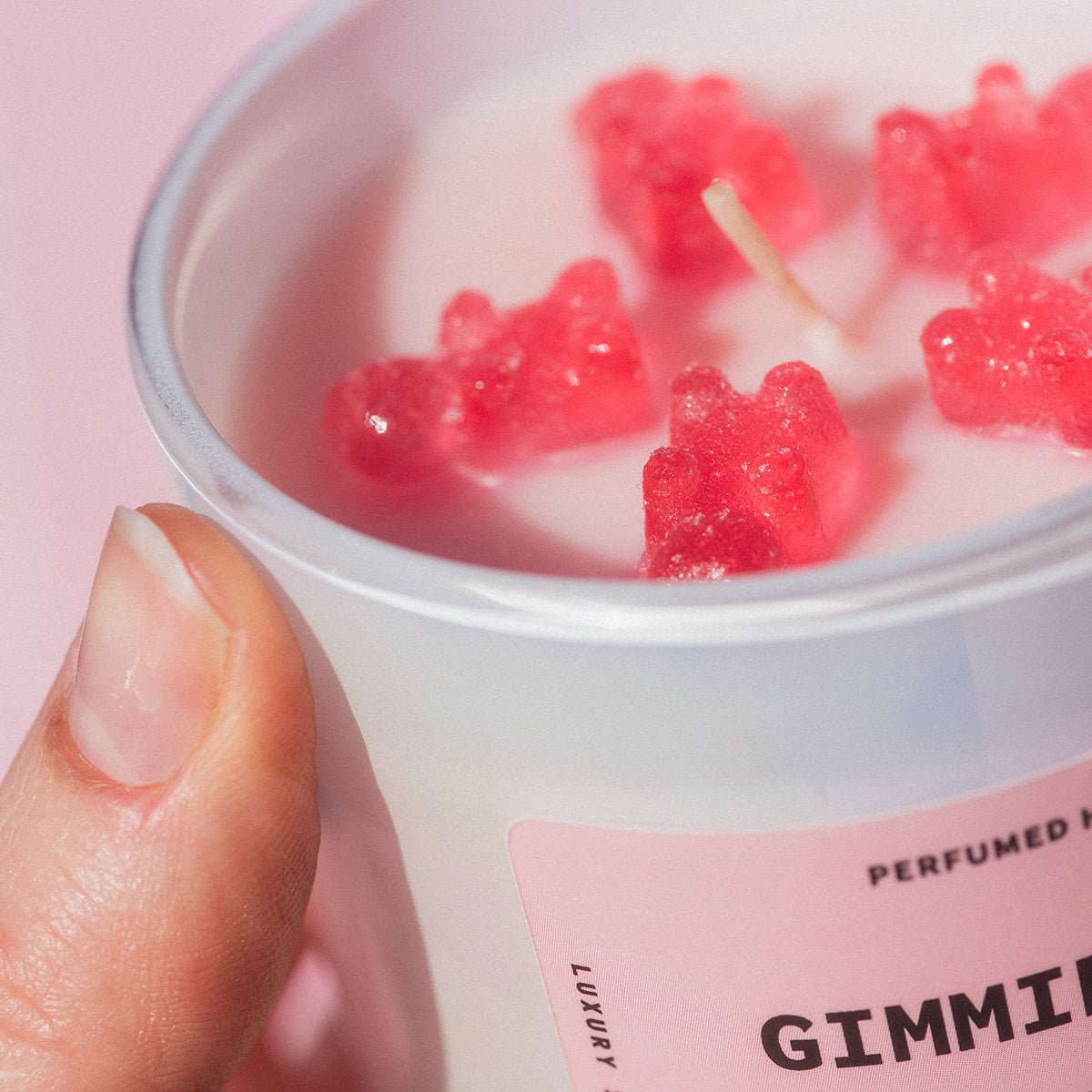 Close-up of gummy bear wax embeds in Candier Gimmie Gummies, a pink candle with sweet scented candles and dessert candles appeal