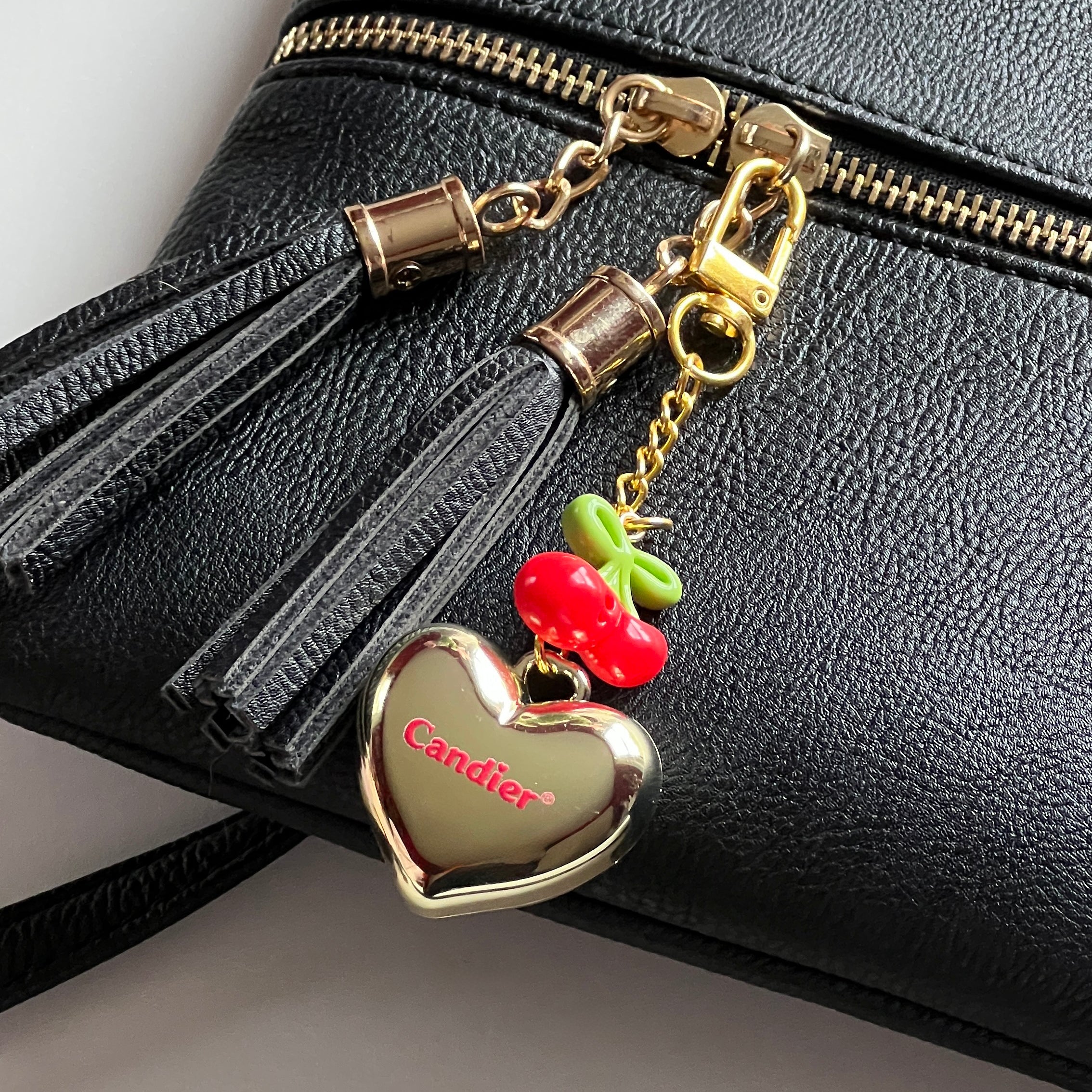 Gold lip balm keychain clipped to black purse – chic gift for her and cool keychain for women