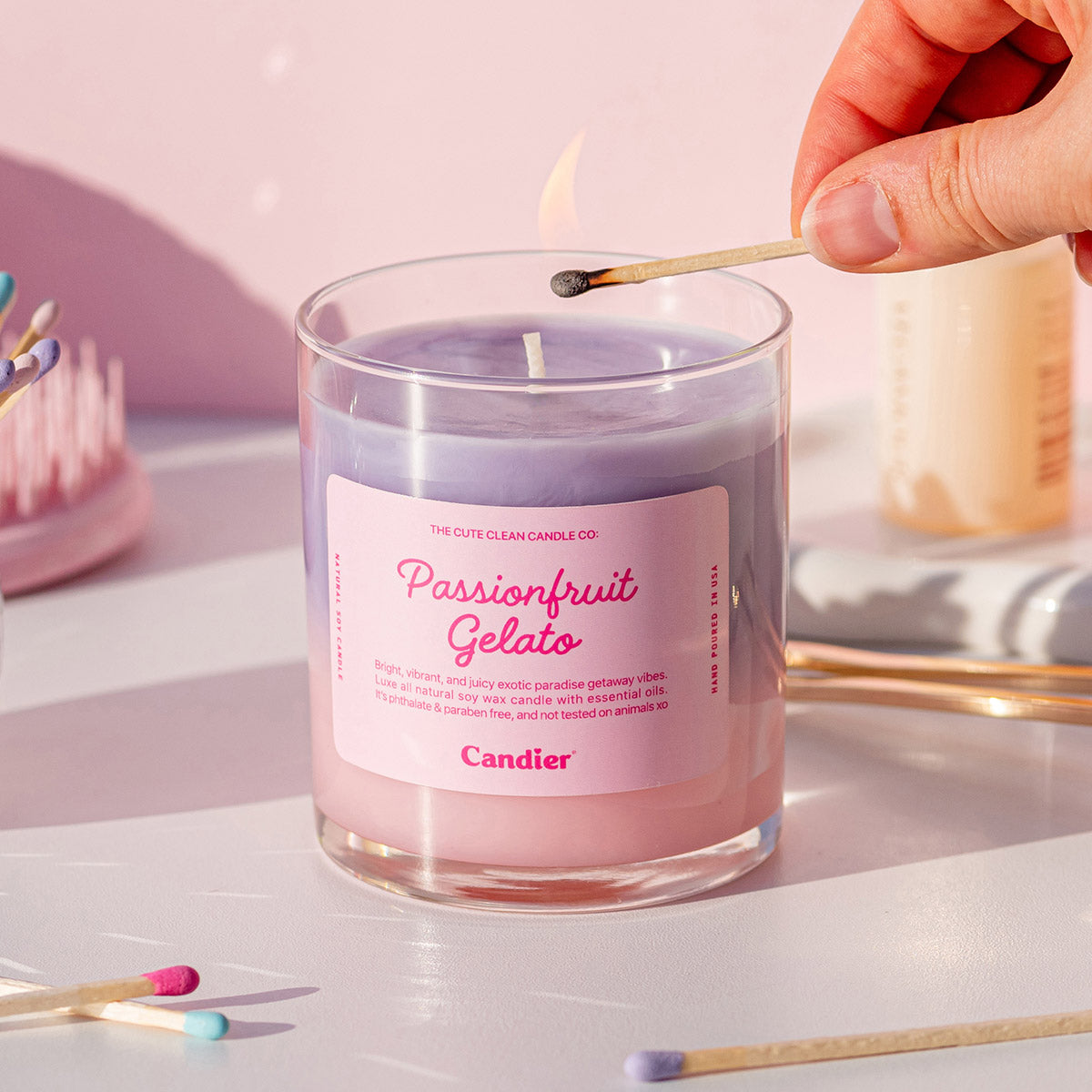 Aesthetic flat lay featuring Candier Passionfruit Gelato Candle with soft girl decor, makeup brushes, and tropical candle vibes.
