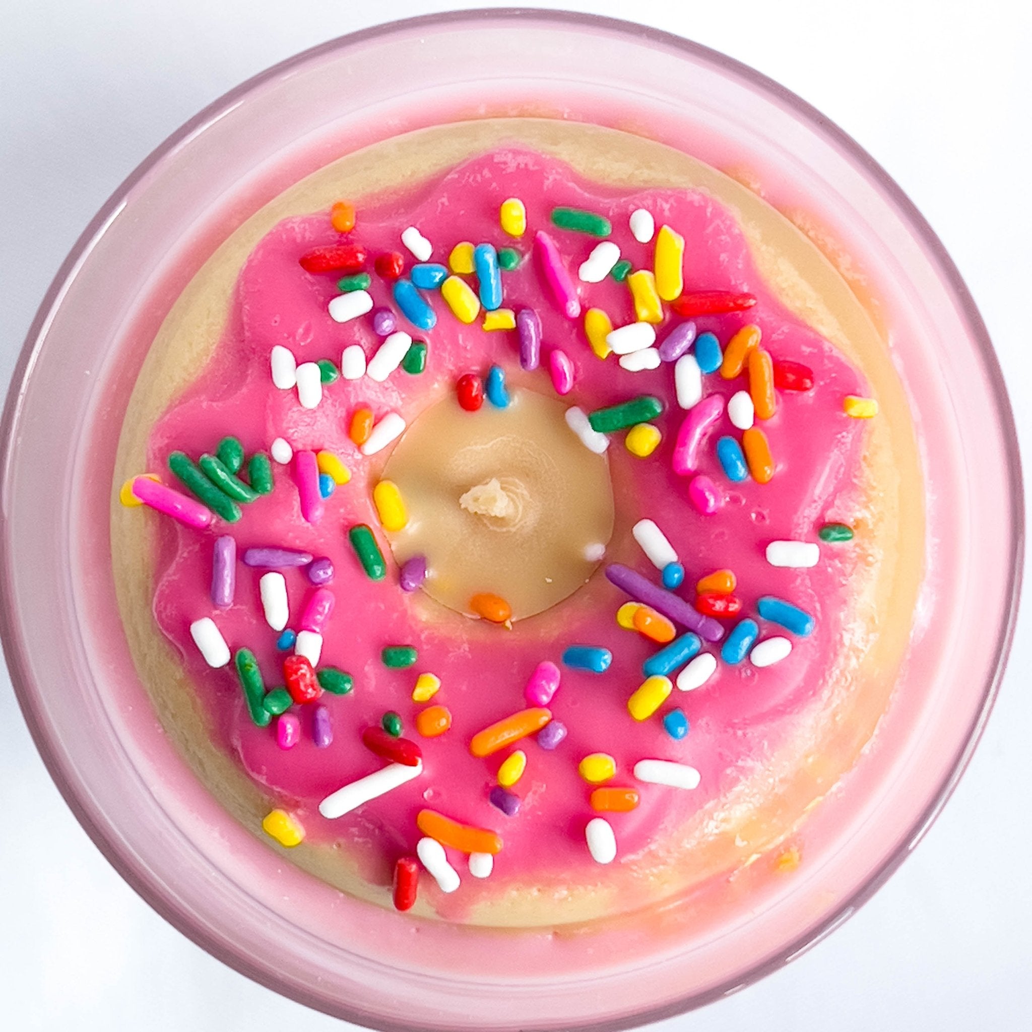 Top view of Candier donut candle featuring hand-poured strawberry glaze wax donut with colorful sprinkles for a realistic dessert candle look