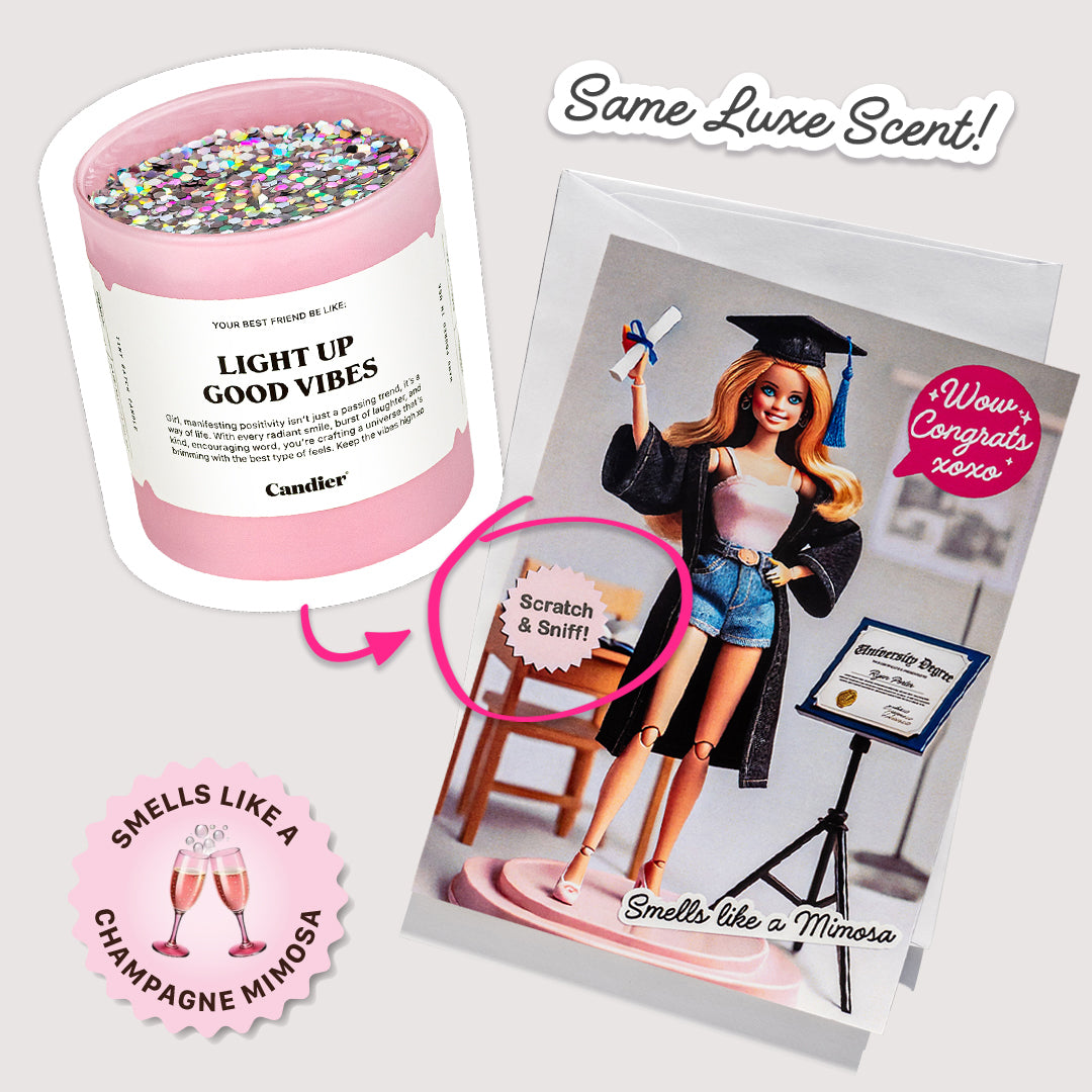 Graduation card next to Light Up Good Vibes Candier candle with champagne mimosa scent.