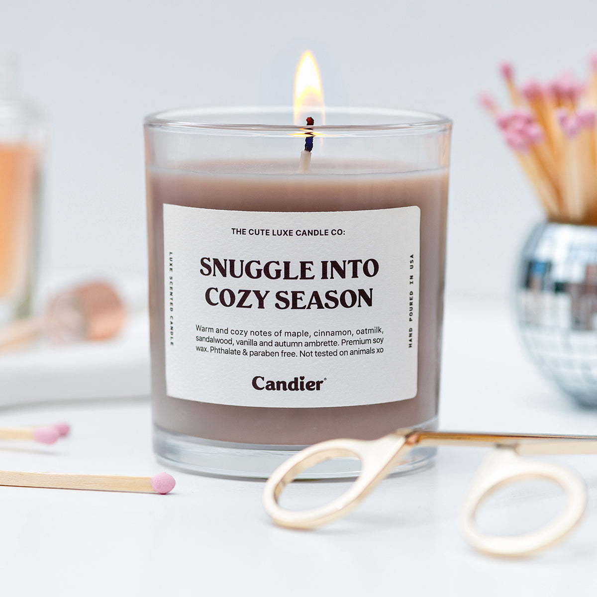 Pretty Candier candle Snuggle Into Cozy Season, a cozy fall candle that makes cute gifts for friends and best gifts for teen girls.
