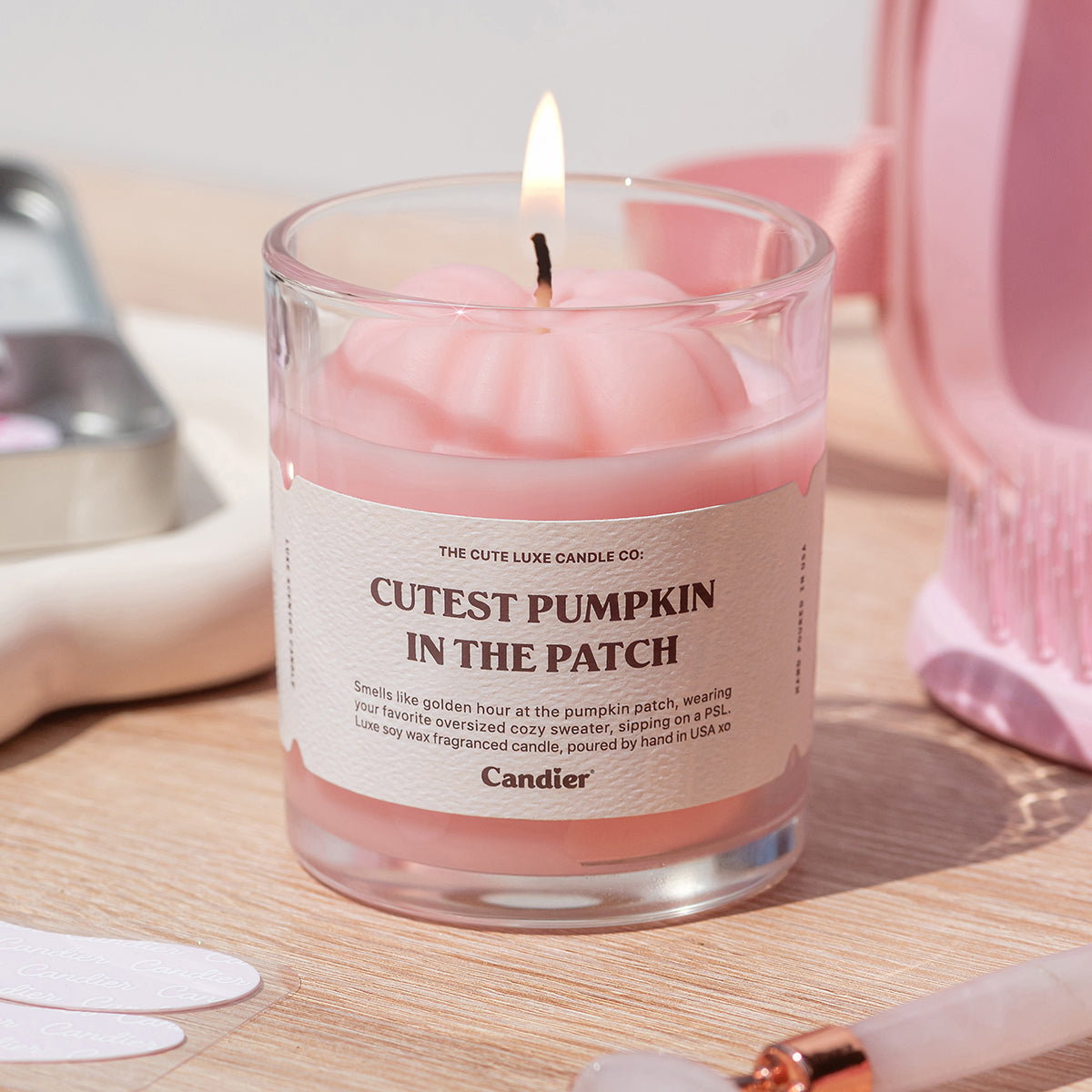 Pretty pink pumpkin decor candle by Candier on a desk. Cozy candles for fall, non toxic fall candles, and luxe aesthetics for home decor.