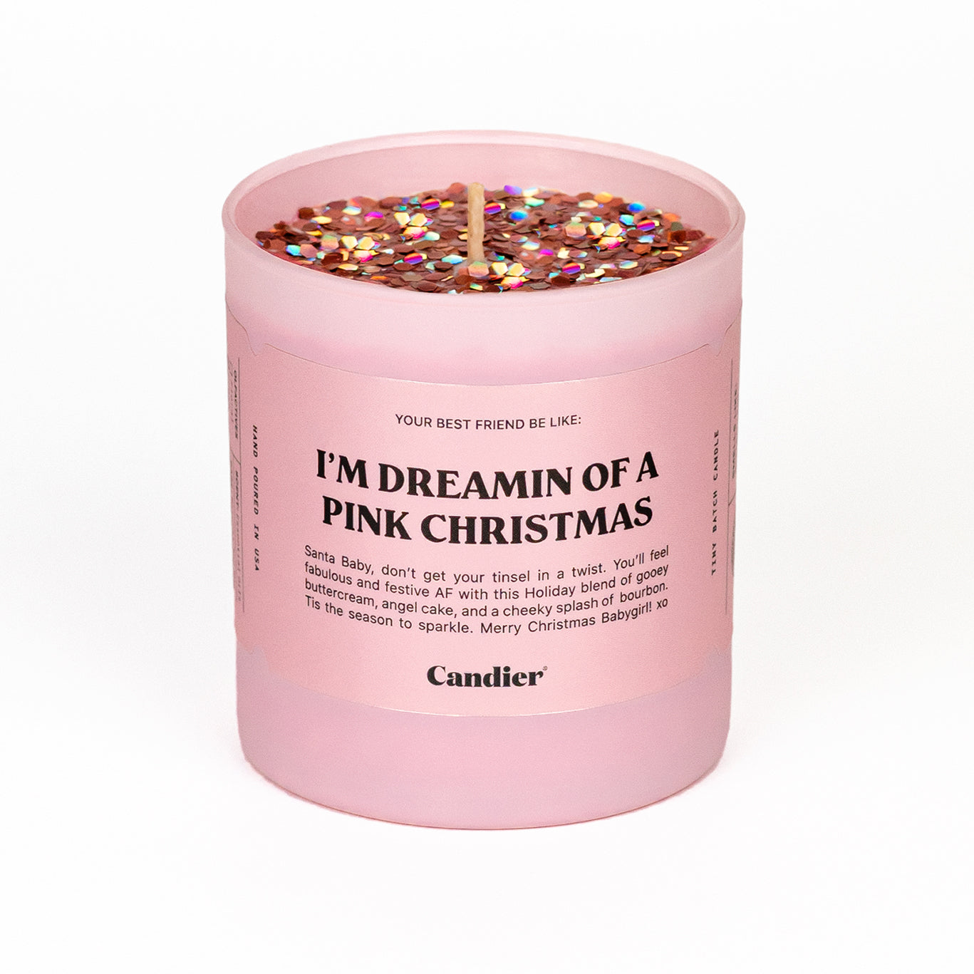 A Candier candle in a matte light pink glass vessel, topped with sparkling pink and holographic glitter, and a label that reads “I”’m Dreaming Of A Pink Christmas”